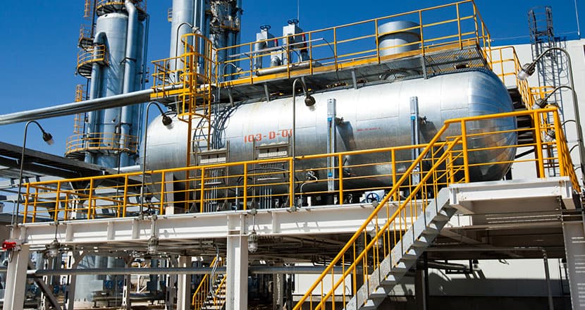 Industrial oil and gas processing platform with yellow structural framework and piping systems