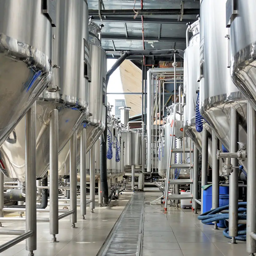 Interior view of beverage production facility with stainless steel tanks